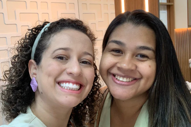 Doutora ao lado de uma paciente sorrindo na recepção