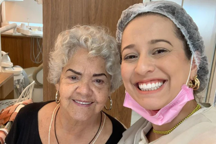 Doutora e paciente de cabelos grisalhos sorrindo juntas
